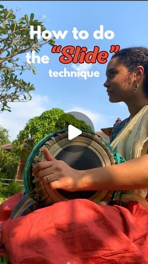 Mridanga Walli on Instagram: "How to do the “slide” technique on the Mridanga! Step 1: Place your wrist on the edge of the black circle on the Mridanga Step 2: Use the tips of your middle finger and your ring finger to bounce on the Mridanga to create an open sound that resonates. Step 3: Keeping your wrist on the Mridanga, combine hitting with tips of your fingers and simultaneously sliding your wrist to the other side to create the “whoop” sound. You’re really using the bottom of your palm rat