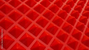 Abstract textured background in the form of red pyramids. Pattern of geometric shapes in the form of a red pyramids.