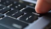 Finger of the computer user, he presses the delete button on the...