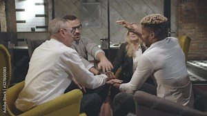 Business people putting hands together and hugging in modern office
