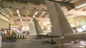 Inside aircraft workshop. Tails of airplanes. Aviation industry development.