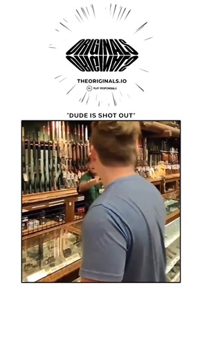 Bimdofy on Instagram: "The ~26-second clip captures a tense yet darkly humorous moment inside a large gun store reminiscent of Bass Pro Shops, complete with taxidermy animals on the walls and rows of rifles on display. A young customer in a blue-gray shirt lifts a green rifle from the rack and points it directly at an older store employee behind the counter. The employee, wearing a green company shirt and glasses, immediately reacts with authority, shouting, “Get down on the fucking ground!” whi