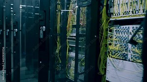 Camera moves through big working data center with server racks . Real shot of high tech server room with metallic doors . Inside telecom server room. Shot on ARRI ALEXA Cinema Camera with gimbal move
