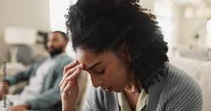 Frustrated couple, headache and fight with argument, disagreement or conflict on sofa at home. Upset man and woman with stress in toxic relationship, breakup or dispute on living room couch at house