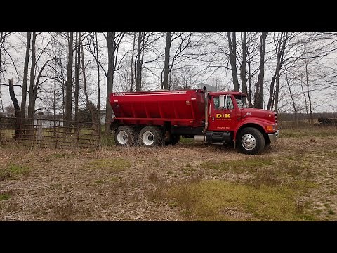 Spreading lime alongside Allis Chalmers tractor doing field work