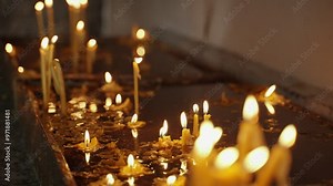 Candles burning in a church or altar during prayer and worship. Lighting the dark room candles lit by visitors and worshipers are burning inside a holy sacred place for christianity