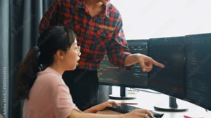 Back end or software developer manager supervising his team on new application program development on debugging and solving complex code algorithms on monitor. Burgeoning