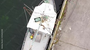 Aerial fishing look-down shot of a fishing trawler docked at a pier along the East Coast in Newfoundland Canada. Stock Video