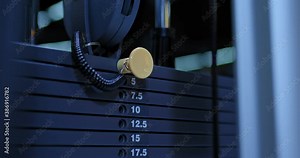 Close-up, the hand rearranges the lever on the metal plates of the simulator. Weight plates on a strength machine. 4k, ProRes