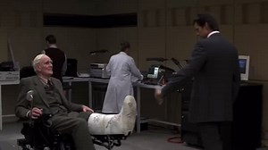 A NEW FACE OF BOND, A FAMILIAR FACE IN Q BRANCH What do YOU think of Bond and Q’s very first meeting in GoldenEye? Leave a comment and let us know. From the very first moment, the tone of Pierce Brosnan’s relationship with Desmond Llewelyn’s Q is perfectly set. Bond strolls into Q Branch. Q appears in an electric wheelchair, leg in plaster. “Morning, Q. Sorry about the leg… skiing?” Q’s face lights up as he fires a rocket from the cast, sending an explosion across the workshop. “Hunting!” And ju