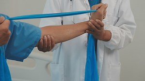 Therapist treating a male injured by rotator cuff stretching method, Physical therapy concept.