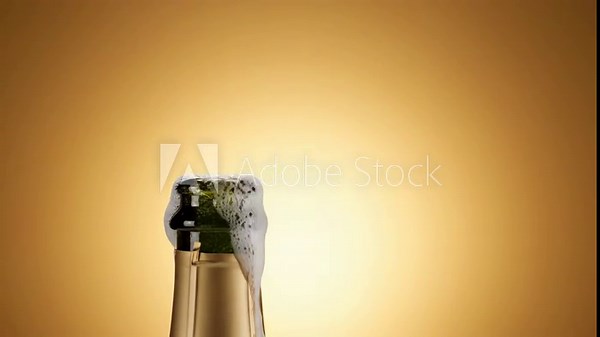 Champagne bottle popping with bubbles against golden background Stock Video