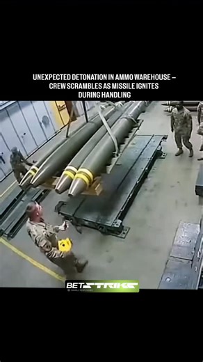 atomicpulsex on Instagram: "In a high-stakes moment captured on security camera, military personnel are seen carefully maneuvering large munitions inside a secure storage facility — until disaster strikes. At approximately 0:04, one of the missiles suddenly ignites, erupting in a blinding flash and billowing smoke. The crew reacts instantly, diving for cover as flames and debris fill the air. The warehouse, lined with rows of identical ordnance, becomes a scene of chaos in seconds. One soldier i