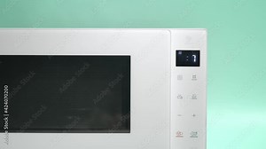 Digital microwave timer counting down from nine.Close up of part of microwave.