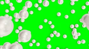 clip-1034324366-falling-rolling-pearls-on-surface-isolated-green