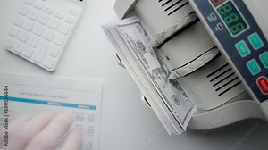 Money counting machine. Dollar banknotes on a bill counter. Modern bank equipment is processing usa currency. Automatic operations of cash. Banking or commercial activity and investment concept