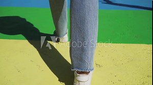 Rainbow crosswalk, Colourful colored crossroad. Woman in denim and sneakers walking on urban.Symbol of gay, Lesbian, Bisexual and transgender, LGBT social movements.