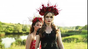 Beautiful women witches in long red and black dresses flowers hoop, outdoor, Santa Muerte carnival Halloween, All saints day, halloween scary concept,