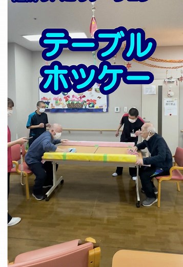 テーブルホッケーで盛り上がるリハビリ