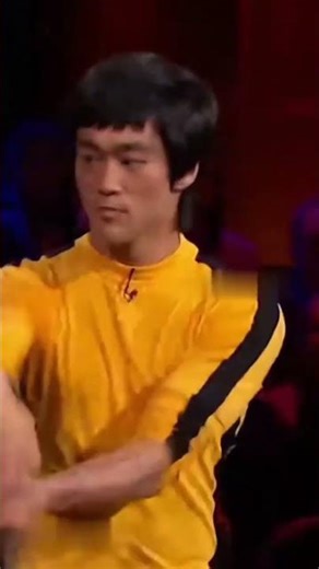 Bruce Lee shows off his special nunchaku skills on a TV show, and everyone is impressed.