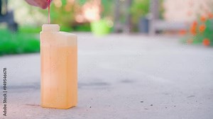 Pink gasoline lubricant is poured into the container for precise mixing of liquids. Preparation of gasoline for a two-stroke trimmer engine. Makes a gasoline-oil mixture
