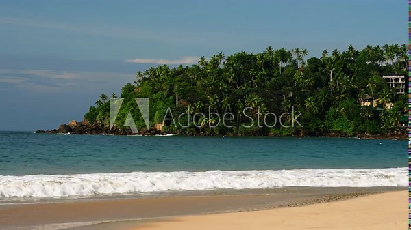 Serenity at Mirissa beach, waves kiss sandy shore, lush greenery covers headland. Perfect for travel ads, postcards, eco-tourism, yoga retreats, real estate showcases, nature documentaries.
