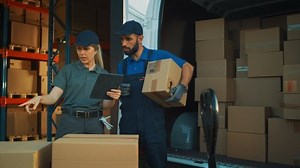 Outside of Logistics Distributions Warehouse With Female Manager Using Tablet Computer, talking to Worker Loading Delivery Truck with Cardboard Boxes. Online Orders, Purchases, E-Commerce Goods