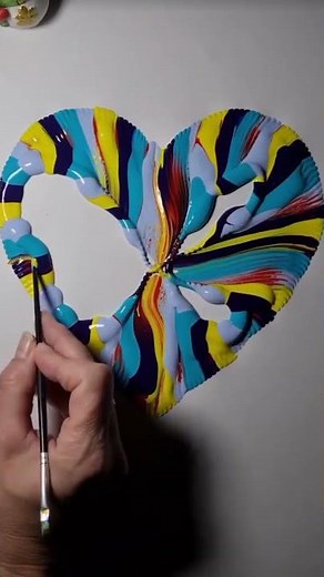 the process of pulling paper strings that depict colorful hearts.