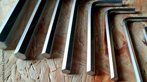 Allen keys laying down in order of size on a wooden table Stock Video