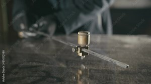 Forge. Smithy. Glass cutting and processing for fireplace doors. Circular glass cutter. Worker cut glass with glass cutting diamond. Polish an angle grinder with an abrasive circular disk nozzle.