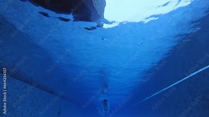 Slow motion of sportsman approaching in butterfly style from one end of swimming pool. Caucasian athlete in googles and special swimwear trains in water. Aqua exercising for being healthy and strong