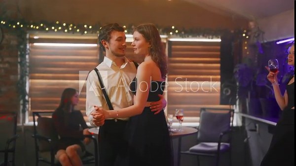 Young couple dancing slow dance in club. Two person man and girl dancing slow dance romantic smiling fall in love at disco party in night club. Teenage love, jealousy, envy, relationship concept.