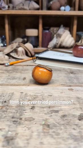 Chris Sisson on Instagram: "Here's another fruit that takes me back to my summers growing up in Japan. My grandparents had a tree growing out front of their house and I'd help my grandfather pick them which he'd later dry and preserve. I was lucky enough that my first experience with them was a delicious one. If you know you know!! Pau Amarello with a touch of dye, madrone threads and lignum vitae leaf cap. #woodturning #fruit #persimmon #japan"