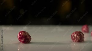 raw meatballs sliding from left to right on a wet white kitchen table. super slow