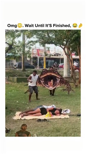 stranger on Instagram: "This viral video depicts a staged prank where a man in a massive frog costume ambushes a sunbathing woman in a park, prompting screams of terror from her and a mock rescue attempt by her companion using a stick, before revealing the costume for comedic effect. Posted by Rwandan telecom professional , the"