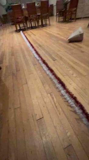 Person uses a drill to twist red and white garland to make a candy cane pattern!