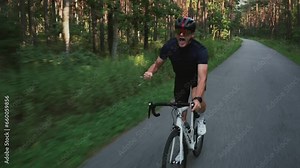 Success, achievement and accomplishment - man cycling cheering and celebrating reaching goal. Male cyclist on road bike in happy celebration with arms outstretched after biking