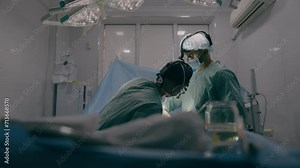 Team of two doctors men surgeons processing surgical operation using endoscopic medical instruments in sterile operating room hospital emergency surgery procedure with anesthesia saving patient life