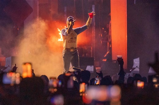 Music superstar falls off stage mid-performance after trying to toast with fans