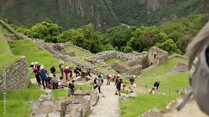 Tourists Exploring Machu Picchu Ruins. Visitors walking through and enjoying the historic site of Machu Picchu