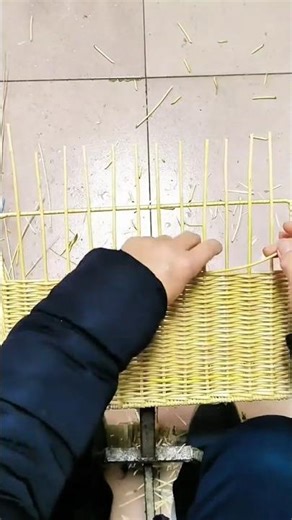 weaving the yellow bamboo skin manually into a basket using thin bamboo sticks