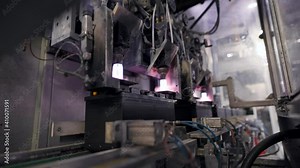 Automatic battery production line. The burner fuses the battery terminals.