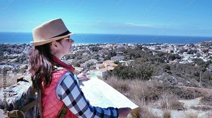 Traveler woman standing on a rooftop with a city map, exploring new destinations