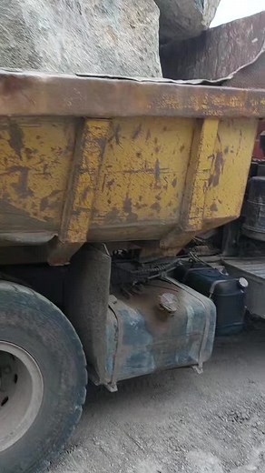Massive Boulder Transported by Dump Truck in Quarry