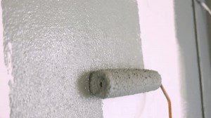 clip-1103302571-man-painting-wall-green-paint-using-roller