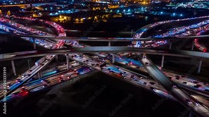 Urban aerial time-lapse drone shot of fast moving freeway traffic at night showing cars with light streaks
