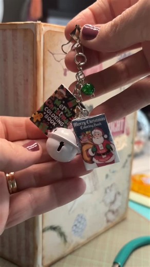 Amanda Jane | Craftee on Instagram: "Using handmade mini Christmas book charms, beads, and mini bell ornament (from Walmart) to make Christmas journal charms. Christmas crafts for journals, albums, cards, and other projects are festive and bright. #diycharms #minibooks #christmascrafts #journalcharms"