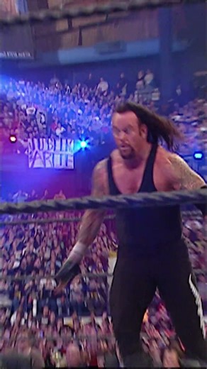 Undertaker launches himself over the casket to obliterate Mark Henry at ringside