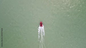 A group of people swim upstream on a motorboat. Red inflatable boat on the river. Azure color of river water