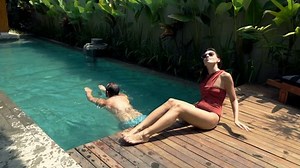 Couple by swimming, man swimming and woman sunbathing, super slow motion 120fps